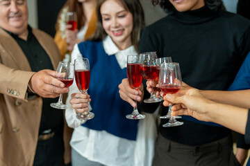 Group of office workers celebrate Christmas and New Year by dancing and drinking wine. Group of international friends and boss dancing with employees.