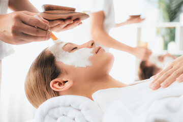 Obraz na płótnie Canvas Serene ambiance of spa salon, couple indulges in rejuvenating with luxurious face cream massage with modern daylight. Facial skin treatment and beauty care concept. Quiescent