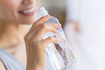 ペットボトルの水を飲む女性 - obrazy, fototapety, plakaty