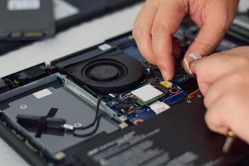 computer technician laptop motherboard repair technician Removing the power connector that supplies...