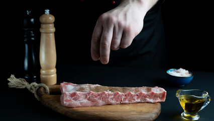 pork ribs with spices on a black background. the concept of recipes and restaurant menus