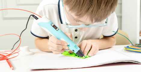 a boy plays with a 3d pen
