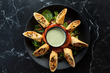 A top down view of a plate of Southwestern egg rolls.
