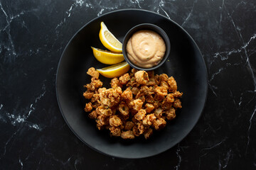 A top down view of a plate of deep fried calamari.
