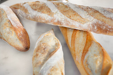 A closeup view of a patio table full of several French baguettes.