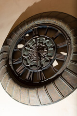 A view of a rustic iron clock as wall decor. 