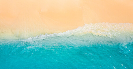 Peaceful aerial wide beach landscape, summer vacation Mediterranean holiday. Waves crash amazing blue ocean bay sea panoramic coastline. Tranquil aerial drone top view. Relaxing sunny beach, seaside