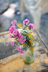 Little blossom pink flowers in glass vase decorated on vintage wooden table in natural garden house