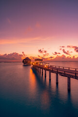 Fototapeta premium Amazing sunset panorama Maldives. Luxury resort villas pier path seascape soft led lights under colorful sky. Beautiful twilight sky fantastic clouds. Majestic beach background best vacation holiday