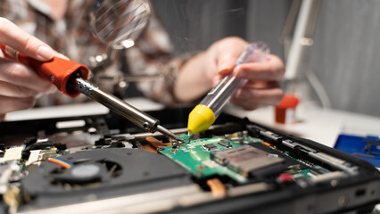 a master with a soldering iron soldering a chip