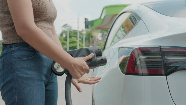 Business woman use EV ccs type2 charge electric car in station ecology transport concept