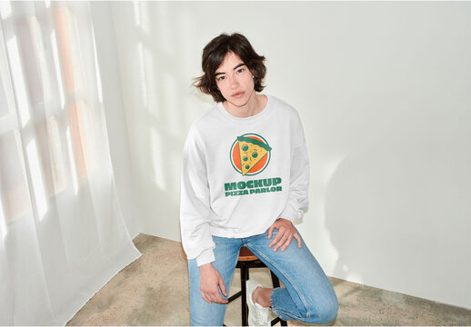 Mockup of woman wearing t-shirt with customizable color and design sitting on stool, high angle, camera flash