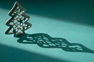 Christmas mitten wooden toy on a blue background with sunlight and shadows. Christmas and New Year...