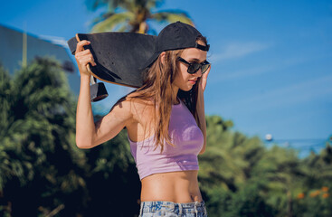 Happy young woman with skateboard enjoy longboarding at the skatepark