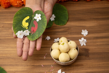 Indian festival Dussehra, sweets green apta leaf in hand or Bauhinia racemosa leaf