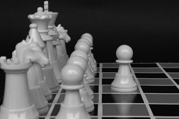 Selective view of chess pawn moving toward for battle with black and white background. Strategy and...