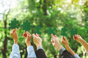 World environment day  and ESG Concept of teamwork and partnership Hands join Jigsaw puzzle pieces with global community sustainable Save Earth. the Environment World Earth Day concept - obrazy, fototapety, plakaty
