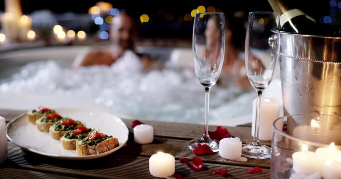 Champagne, food and hot tub couple romance, love and bond on Valentines day date, anniversary or honeymoon. Jacuzzi night, candle and happy man, woman or marriage people with alcohol glass and snack