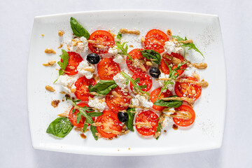 Caprese salad with mozzarella cheese, tomatoes and basil