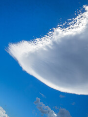 A large lenticular cloud shaped like an upside-down jellyfish formed in the sky over the lee of...