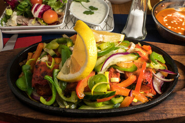 A chicken sizzler dish with chicken and vegetables.