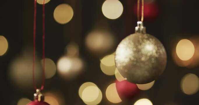 Video of gold and red christmas baubles decorations with copy space on black background