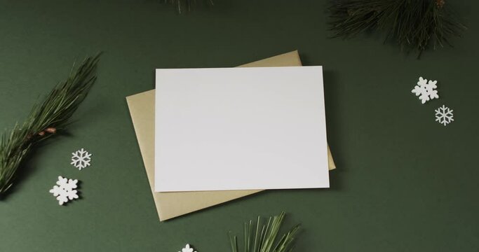 Video of christmas decorations and white card with copy space on green background