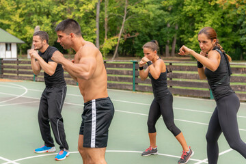 A group of individuals participating in Tae Bo training outdoors, enhancing physical fitness and well-being