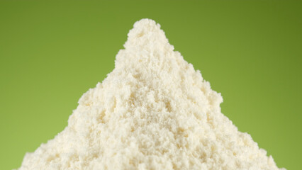 White protein, whey powder on green background. Bodybuilding, fitness and gym lifestyle