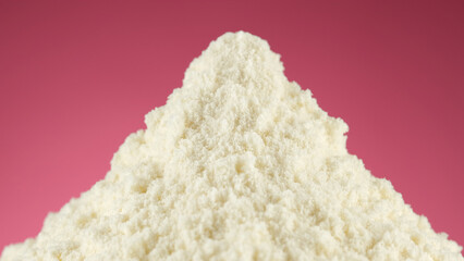 White protein, whey powder on pink background. Bodybuilding, fitness and gym lifestyle