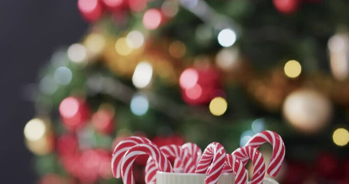 Video of white mug with christmas cnady canes and christmas tree lights with copy space