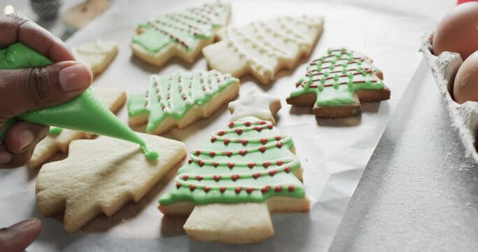 Video of christma cookies being decorated with green sugar icing with copy space on white background