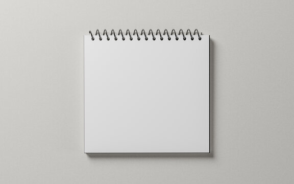 white blank notepad sheet mockup. spiral calendar on gray background. square shape notebook. top view. copy space