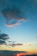 Beautiful blue sky with dark clouds. Sunset, evening, dramatic sky. Cumulus and cirrus clouds.