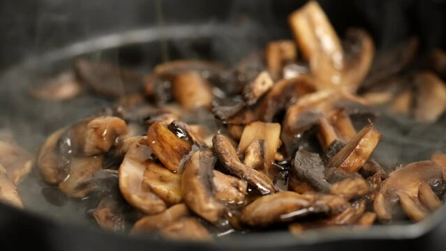 Zoom frame fried champignons mushrooms in pan