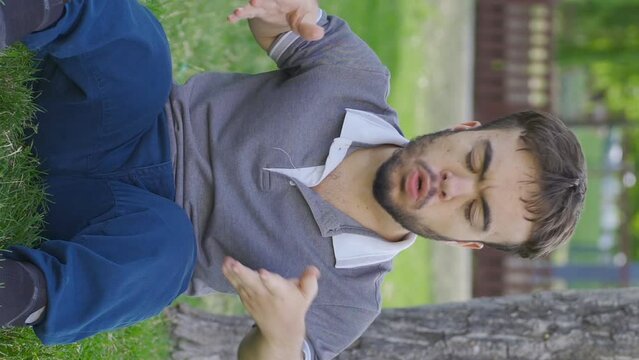 Vertical Video of Self-motivated dwarf young man in the park. Upload motivation.