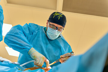a surgeon performs an operation with a hospital