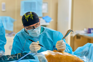 a surgeon performs an operation with a hospital
