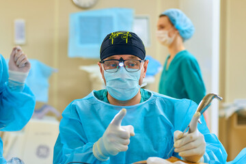 a surgeon performs an operation with a hospital