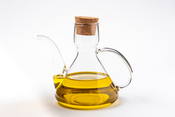 Typical oil jug with gold-colored virgin olive oil, white background.