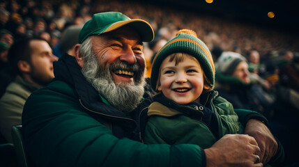 Irish father and son in stands, filled with enthusiastic supporters of rugby or football team...