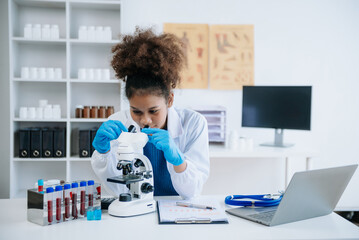 .Young scientists conducting research investigations in a medical laboratory, a researcher in the...