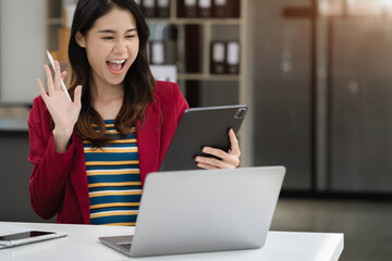 Excited woman work distant on computer talk on cellphone celebrate online win. Happy young female...