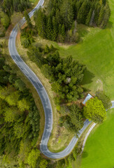 Portrait format of romantic Lechtal Alps pass road which winds through the green forest with hairpin bends - obrazy, fototapety, plakaty