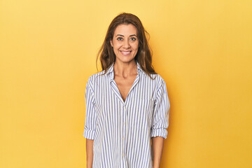Middle age woman smiling on yellow background