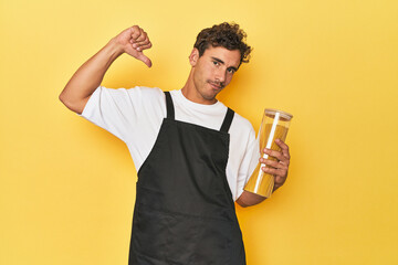 Young latino man cook with pasta jar on yellow feels proud and self confident, example to follow.