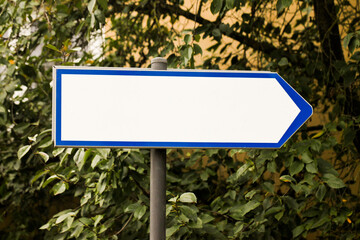 Dirrection arrow. Signpost outdoor. Empty copy spacesign. Tourist information. Guide blank space. Forest road hikinh trail. Tree leaves in the background. City park landscape.