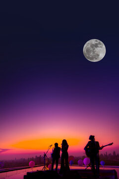 Vertical image of silhouetted trio musician sings song on skyscraper with twilight sky and full moon background.