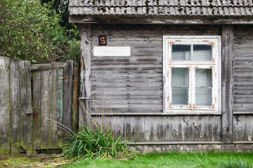 Old house. Ruined wooden building. Grunge destroyed window. Backyard gate wrecked. Abandoned home background. Bad condition broken window.	Blank street name sign. Countryside village architecture.