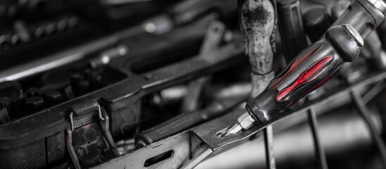 Screwdriver and other mechanical work tools on workbench